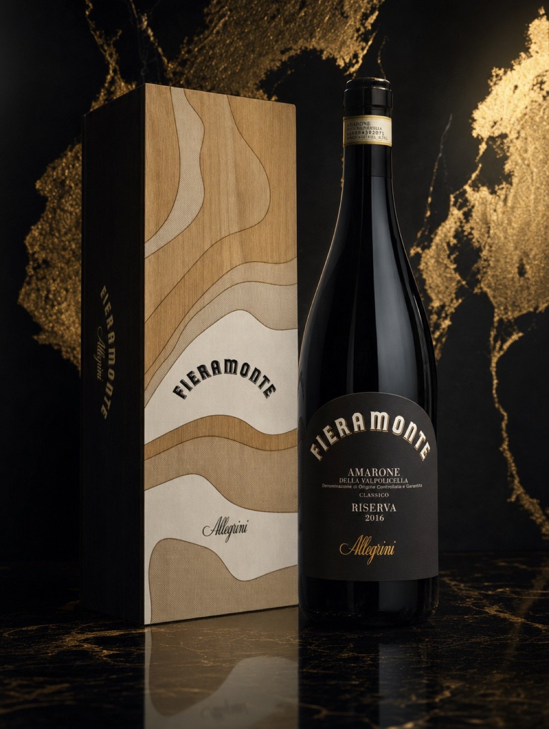 A bottle of Allegrini Fieramonte Amarone della Valpolicella Classico Riserva 2016 standing beside its inlaid wooden presentation box on black and gold marble