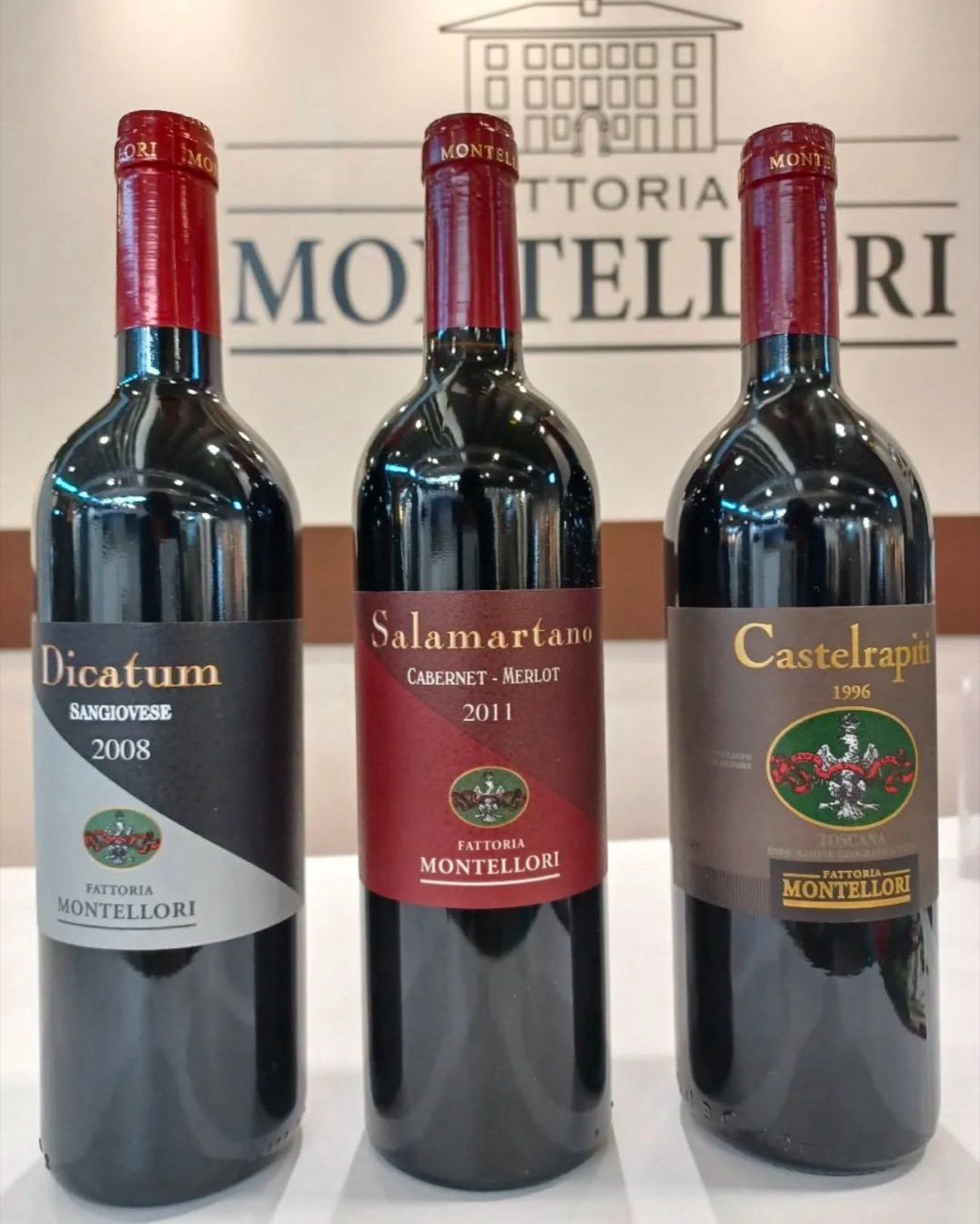 Three Fattoria Montellori bottles in front of the estate sign